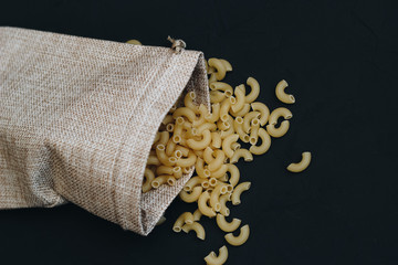 Noodles in a linen bag on a black background