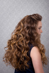 Naklejka premium Female hairstyle long curls close-up rear view.