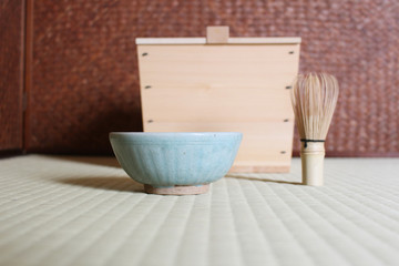 Fototapeta na wymiar Making matcha green tea with pottery tea cup and bamboo whisk 
