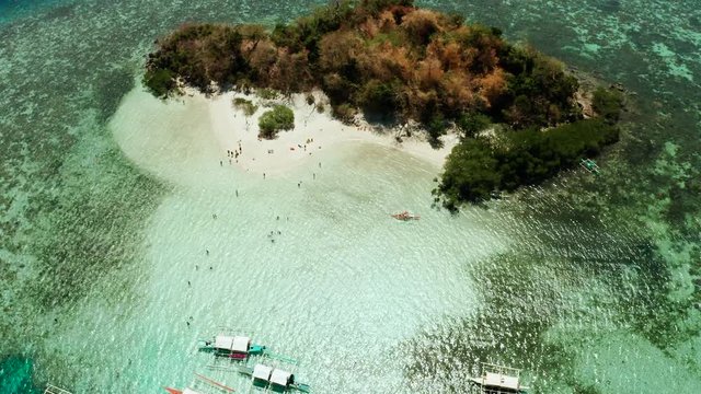 aerial seascape tourists enjoy tropical beach. tropical island with sand beach CYC, palm trees. Philippines, Palawan. Tropical landscape with blue lagoon, coral reef