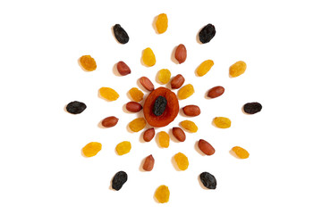 Pattern of Nuts - yello, brown raisins, dried apricots and peeled peanuts on a white background in the form of a circle. Concepts about decoration, healthy eating and food background.