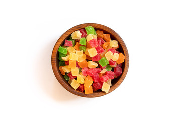 Candied dried pineapple yellow, orange,  red and green  in a wooden cedar plate on a white isolated background. Row of bowls with pineapple , top view. dried pineapple  pattern
