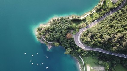 Up and down drone aerial view of the lake Ledro. A natural alpine lake. Amazing turquoise, green and blue natural colors. Italian Alps. Italy. Touristic destination. Summer time - Powered by Adobe