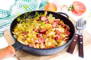 Fried cabbage with smoked sausages in pan