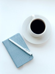 Notepad and cup of coffee on a white background