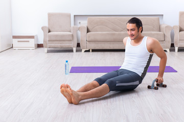 Obraz premium Young man training and exercising at home