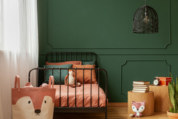 Copy space on empty dark green wall of trendy bedroom interior