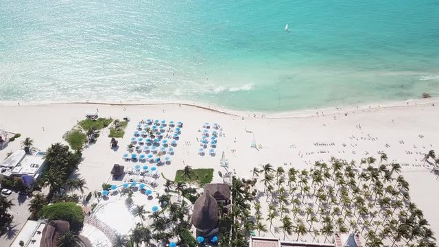 Top view of beautiful beach. Aerial drone shot of turquoise sea water at the beach. Luxury tropical resort with white sand. Aerial view