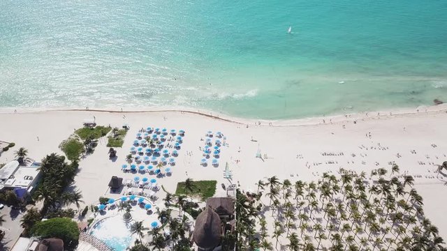 Top view of beautiful beach. Aerial drone shot of turquoise sea water at the beach. Luxury tropical resort with white sand. Aerial view