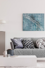 Abstract blue painting on empty white wall of open plan apartment