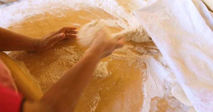 a woman in the kitchen making pita bread of dough and flour with a wooden rolling pin. preparation of national Armenian lavash. 4 to slow motion