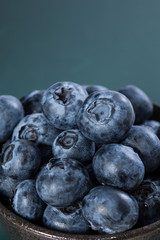 Blueberries in a brown bowl with green space for text
