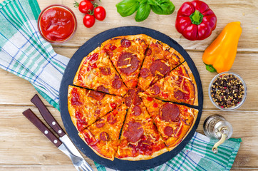 Pizza with salami, cheese and fresh vegetables