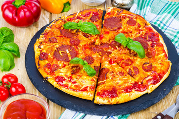 Pizza with salami, cheese and fresh vegetables