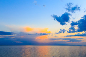 Beautiful sunset on a lake in the mountains. Kyrgyzstan, Issyk-Kul Lake. Bright sky, background in warm colors.