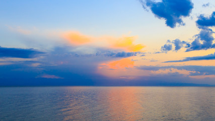 Beautiful sunset on a lake in the mountains. Kyrgyzstan, Issyk-Kul Lake. Bright sky, background in warm colors.