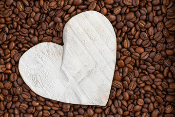 Coffee beans arranged with a hand-crafted white wooden heart symbolise not only health, but of the love of coffee.