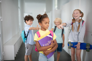 Obraz premium Dark-skinned girl suffering from bullying at school