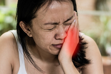 Temporomandibular Joint and Muscle Disorder: TMD concept. Woman hand on cheek face as suffering...