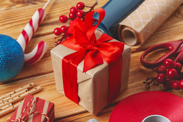  wrapping gift boxes with equipment and decorating items on wooden background