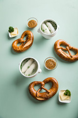 Münchener Weißwurst in Terrine mit bayrischer süßen Senf, Brezel und Butter auf Pastell grünen...