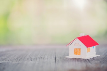 Red Roof House Model On Old Wooden Floor Nature Bokeh Background