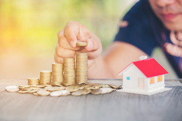 Hold put on the stack coin with growing in the public park, Savings money for buy house and loan to business investment for real estate concept.