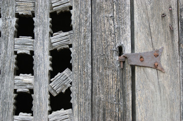 antique metal door hinge.  wooden window with old forged door hinge