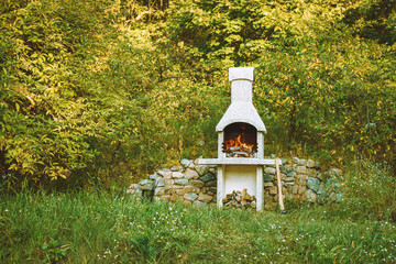 Stone garden oven for grill or barbeque is in a backyard