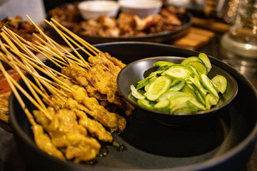 Grilled pork satay with peanut sauce and pickled cucumber