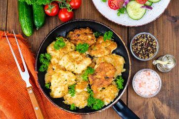 Fried meat pancakes in pan, vegetables, wooden background