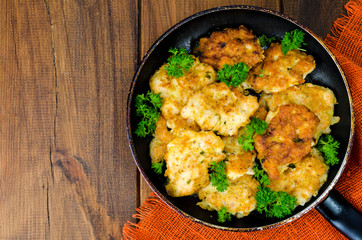 Fried meat pancakes in pan, vegetables, wooden background