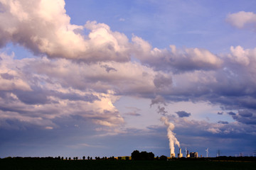 wind turbinesnand power plant in front of a cloudy sky in a colorful and vivid evening athmosphere
