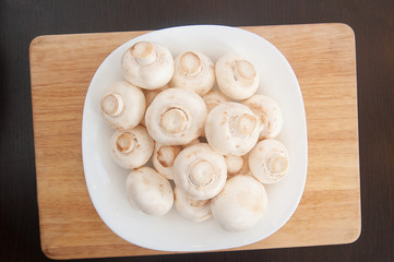 fresh mushrooms on a white plate on the table