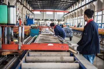 Fototapeta premium Luannan County, Tangshan City, China - October 20, 2016: Mechanical equipment and finished products in the workshop of aluminium alloy products factory, and skilled workers are working.