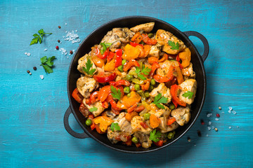 Chicken Stir fry with vegetables on blue table.