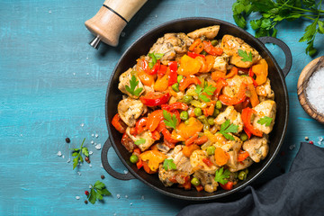 Chicken Stir fry with vegetables on blue table.