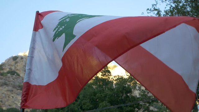 Lebanon Flag waving in the wind with mountains in the background