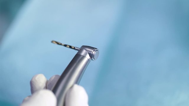 close-up view of little bor machine in hand of dentist in dental office, preparing for treatment