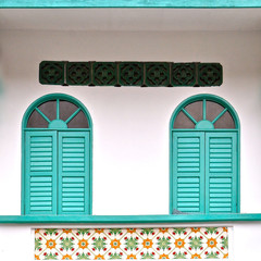 Two turquiose wooden shuttered wondows.
