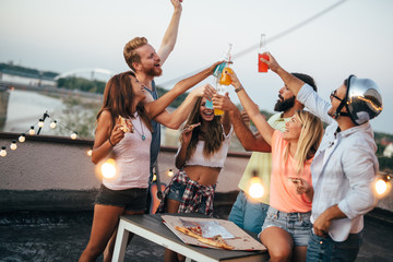 Group of young people having fun at a summertime party, at sunset
