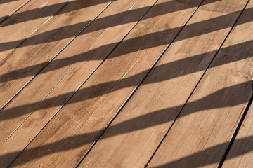 Wooden terrace floor with balusters shadow