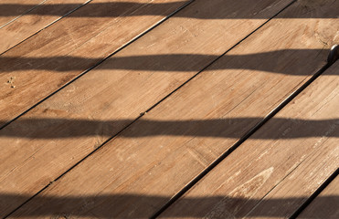 Wooden terrace floor with balusters shadow