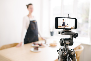 Woman vlogger recording video for food channel. Cooker shef recording a video for vlog with a phone