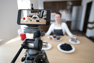 Woman vlogger recording video for food channel. Cooker shef recording a video for vlog with a phone