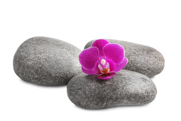 Pile of spa stones and orchid flower on white background