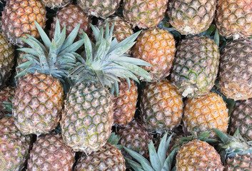 Ripe juicy pineapple background. Pineapple pile on the market
