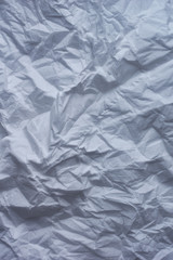 The crumpled background of the unfolded white paper