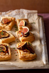 fig puff pastry tarts on baking tray. selective focus