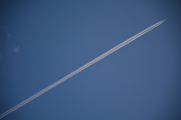 Trail of a jet plane in the blue sky